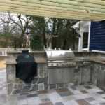 Outdoor kitchen with built-in appliances and pergola 