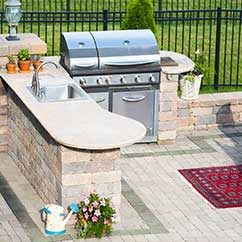 Outdoor kitchen area with grill and sink